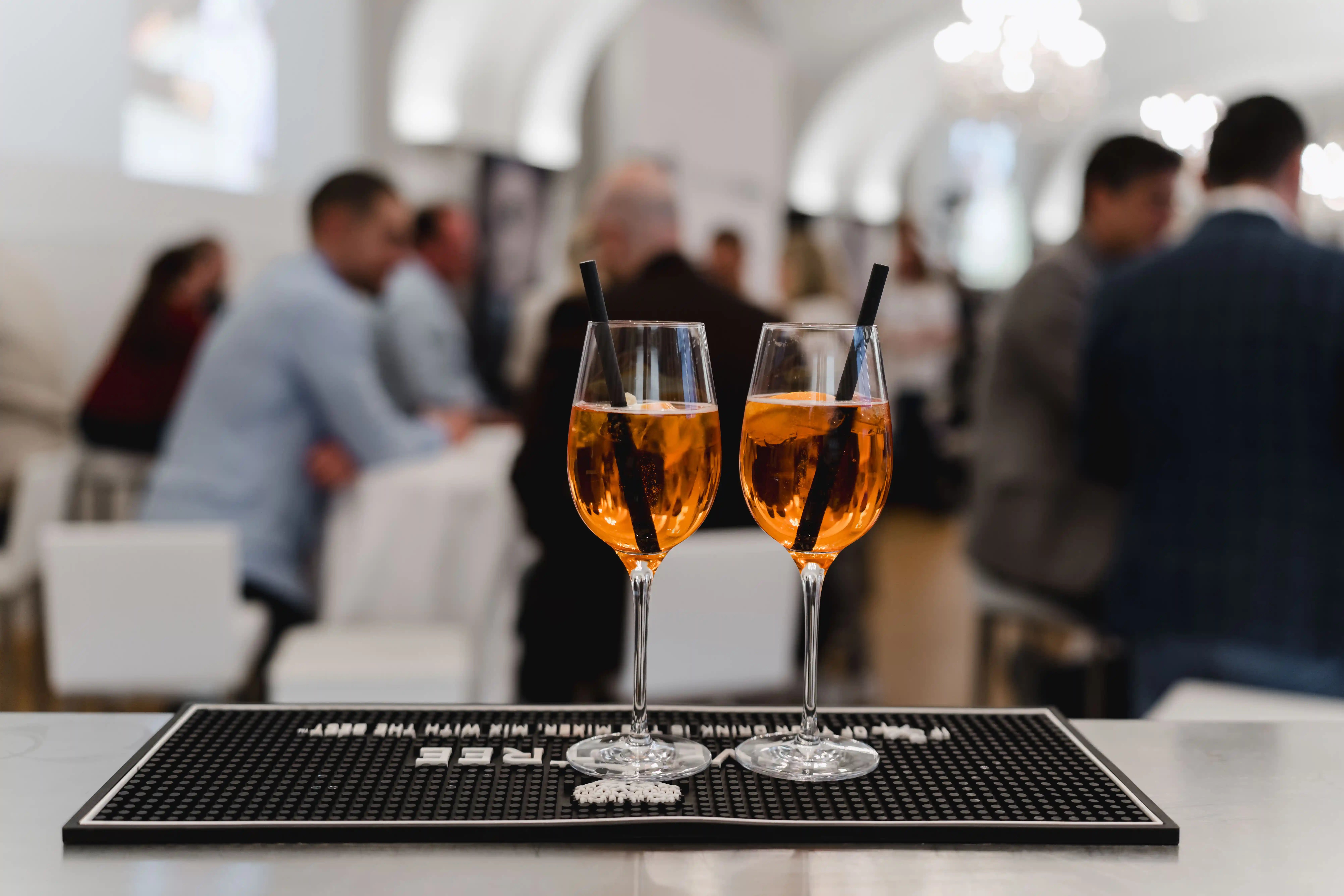 Cocktailgläser auf einem Tablett - im Hintergrund TN der Space Night bei Service Space
